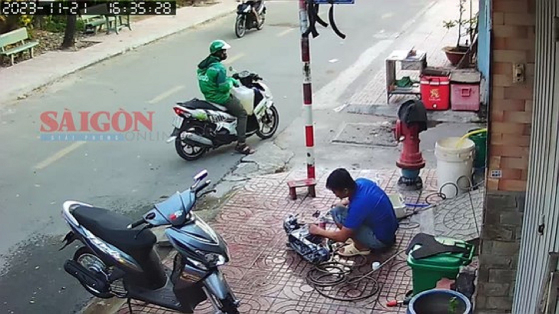 Nghi phạm Nguyễn Văn Nhu mặc áo Grab đứng ở đầu hẻm trước khi gây án.
