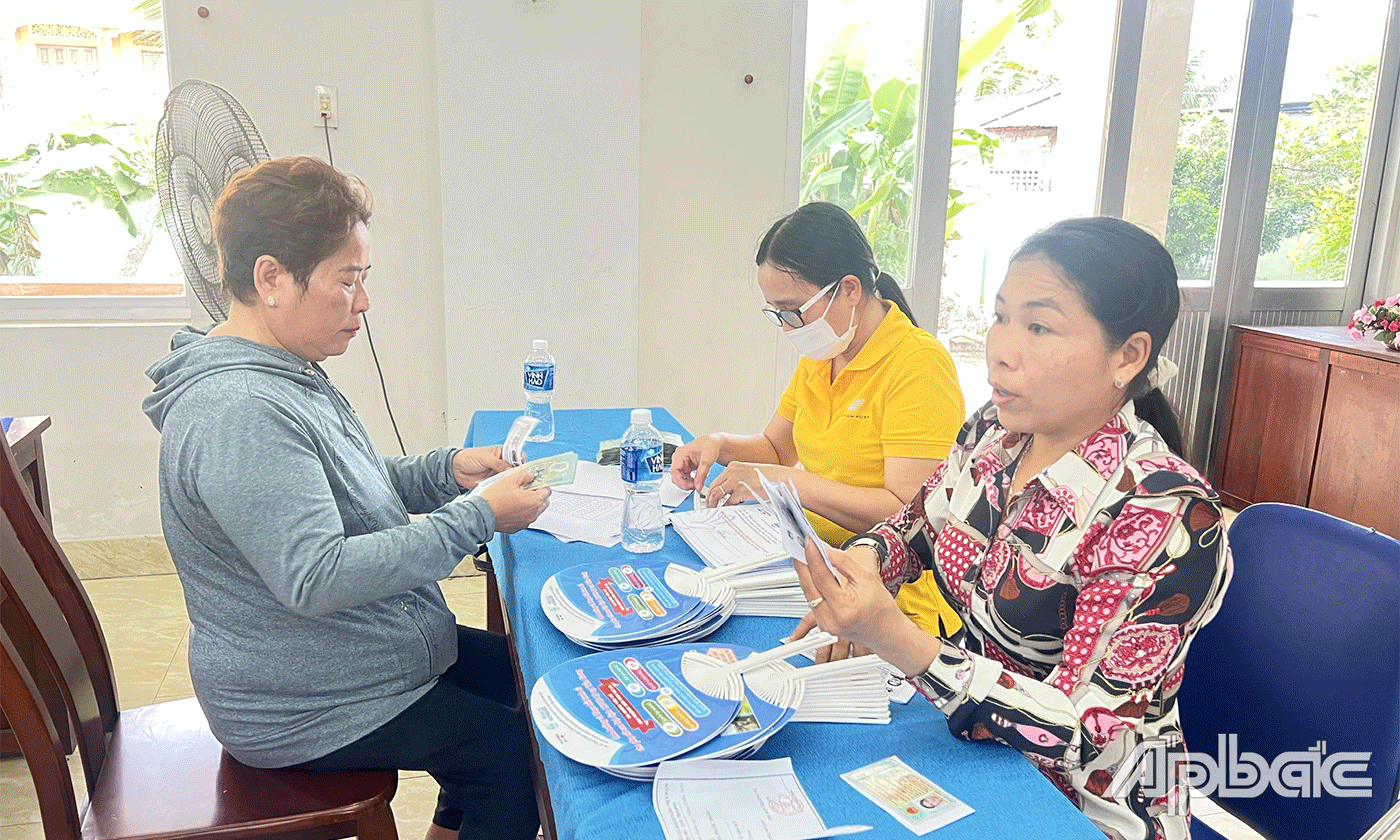 Trao tiền hỗ trợ cho các đối tượng hưởng lợi.
