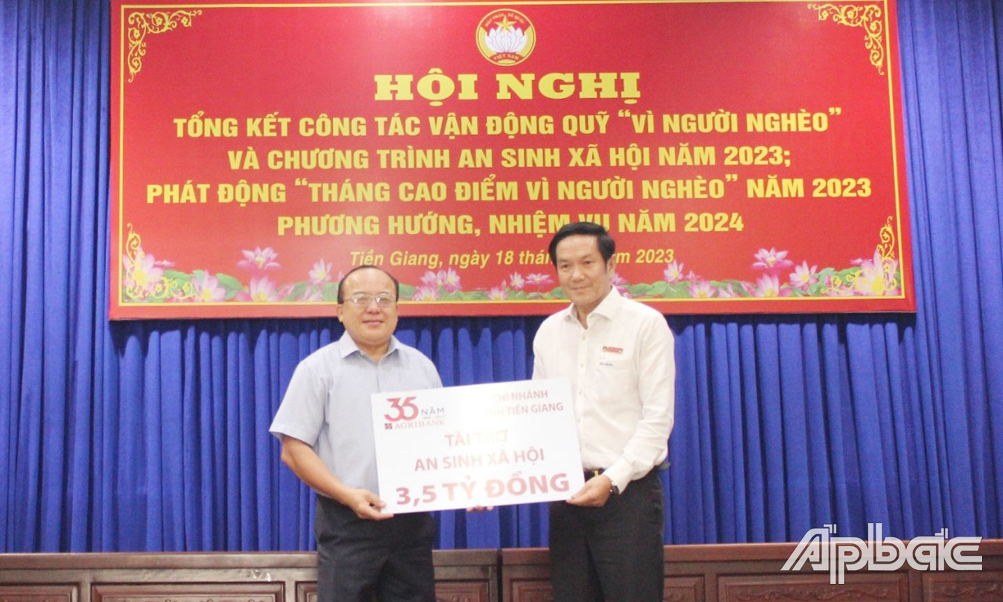 Ông Trương Văn Đoàn, Phó Giám đốc Agribank chi nhánh tỉnh Tiền Giang trao biển tượng trưng số tiền ủng hộ Quỹ “Vì người nghèo” tại Lễ Phát động tháng cao điểm “Vì người nghèo năm 2023” cho Đồng chí Nguyễn Chí Trung, Ủy viên Ban Thường vụ Tỉnh ủy, Chủ tịch Ủy ban MTTQ tỉnh Tiền Giang (bên trái)