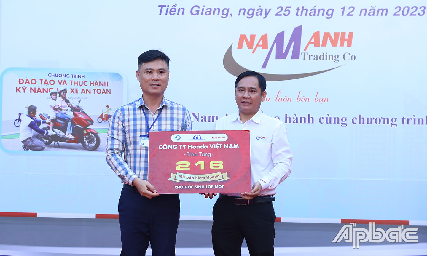 Đại diện Công ty Nam Anh trao nón bảo hiểm cho trường.