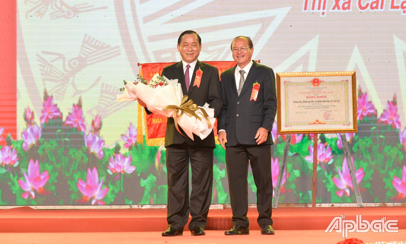Đồng chí Trần Văn Thức, Phó Bí thư Thị ủy, Chủ tịch UBND TX. Cai Lậy thay mặt Đảng bộ, Chính quyền và nhân dân thị xã tặng hoa cảm ơn đồng chí Nguyễn Văn Vĩnh.