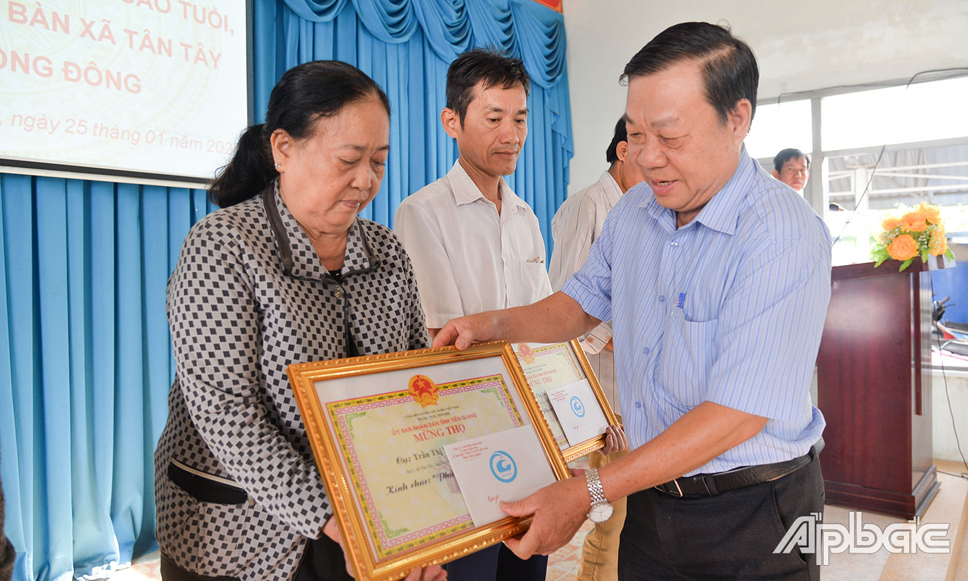 Đồng chí Nguyễn Ngọc Trầm trao quà cho đại diện hộ có người cao tuổi.