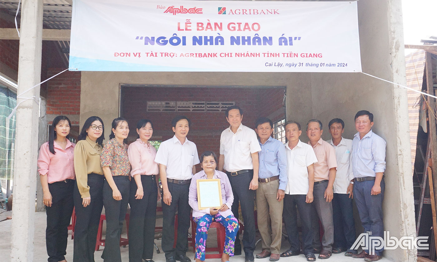 Đại biểu chụp ảnh lưu niệm cùng gia đình bà Huỳnh Thị Tuyết Mai bên căn nhà mới.