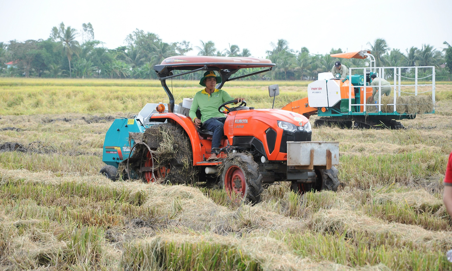 Máy cuộn rơm trên cánh đồng lúa sau thu hoạch tại Hậu Giang.