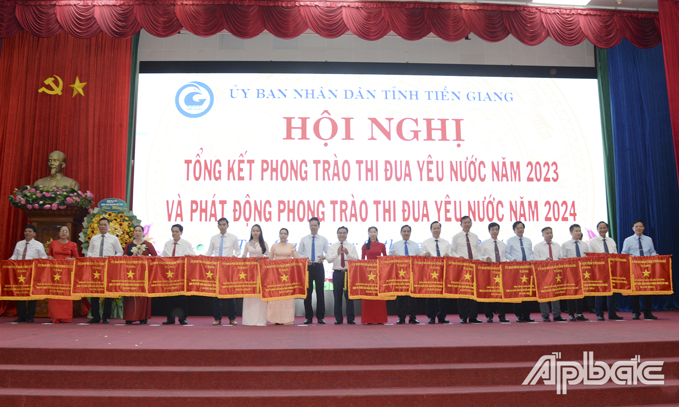 đồng chí Trần Văn Dũng, Ủy viên Ban Thường vụ Tỉnh ủy, Phó Chủ tịch UBND tỉnh và đồng chí Nguyễn Thành Diệu, Tỉnh ủy viên, Phó Chủ tịch UBND tỉnh trao Cờ thi đua của tỉnh cho các tập thể trao 