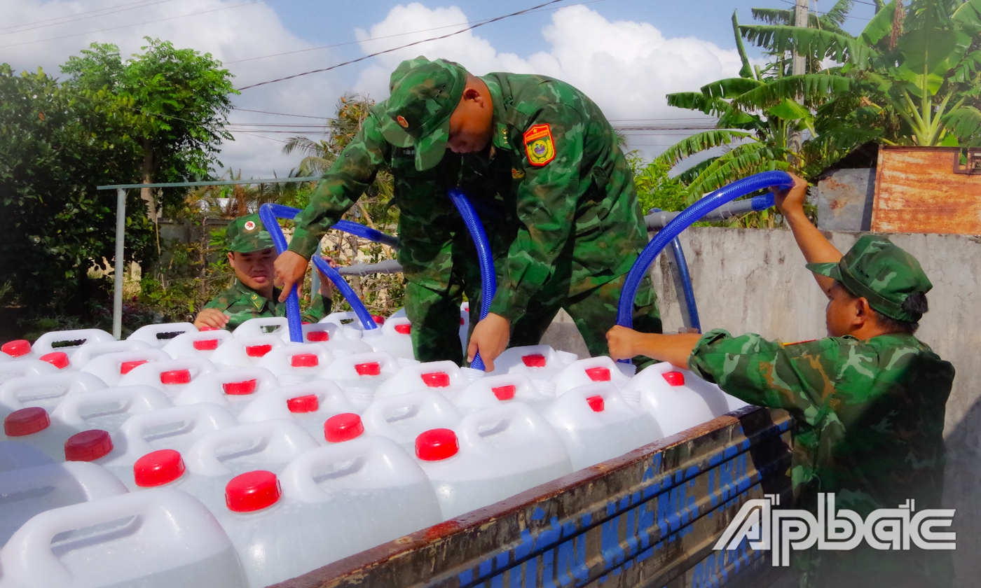 Cán bộ, chiến sĩ Đồn Biên phòng Tân Thành bơm nước sạch để vận chuyển đến các hộ thiếu nước sinh hoạt.