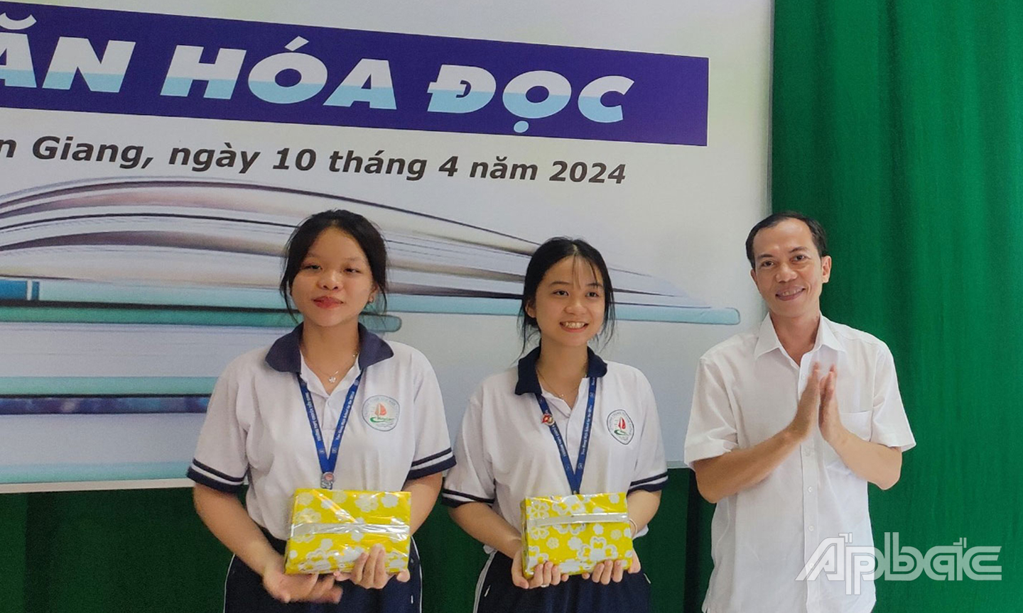 Giám đốc Thư viện tỉnh Tiền Giang Võ Nam Phước trao quà cho các em.