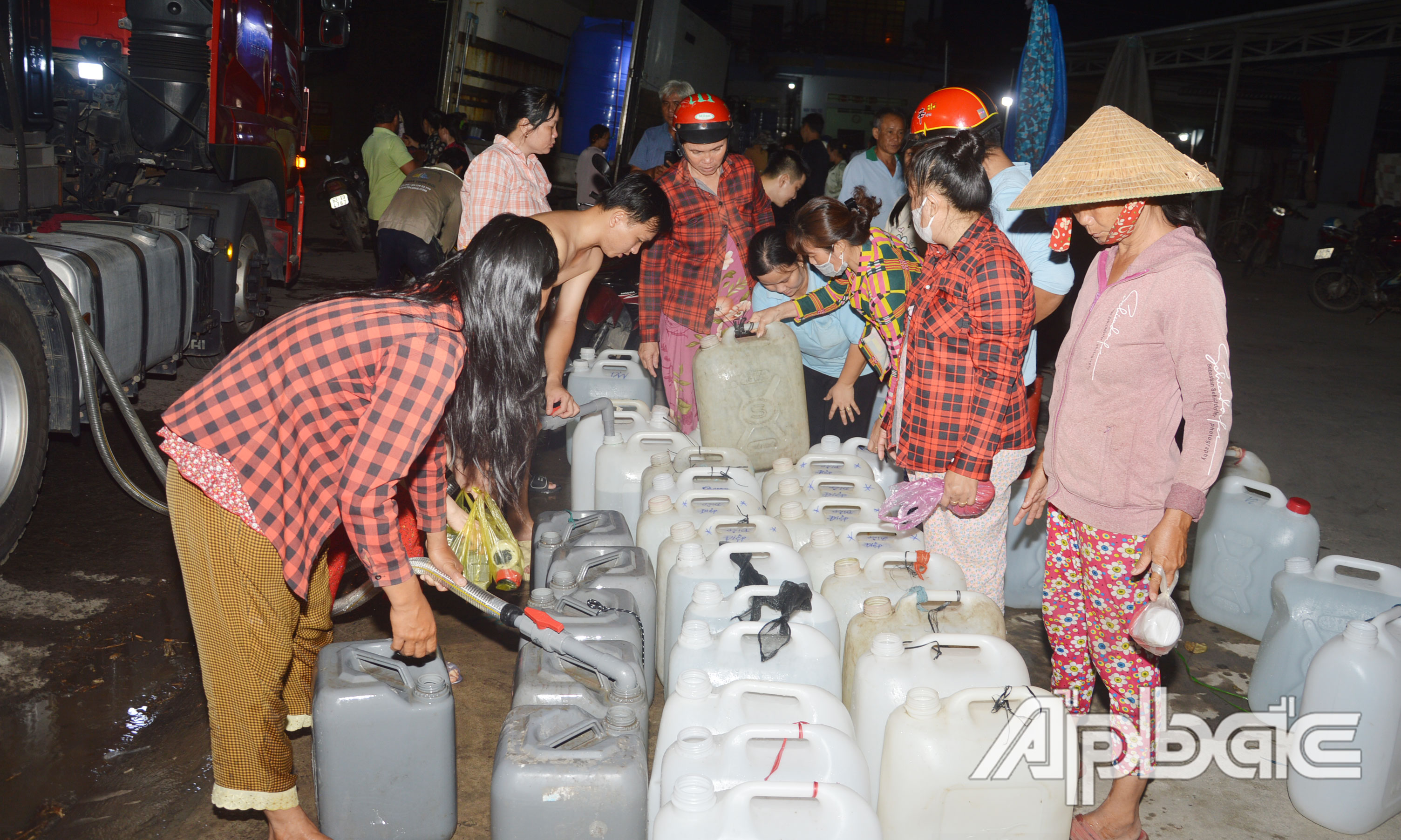 Bất kể ngày đêm, hễ hay tin có xe chở nước miễn phí đến là người dân lại mang can, thùng ra để lấy về sử dụng.
