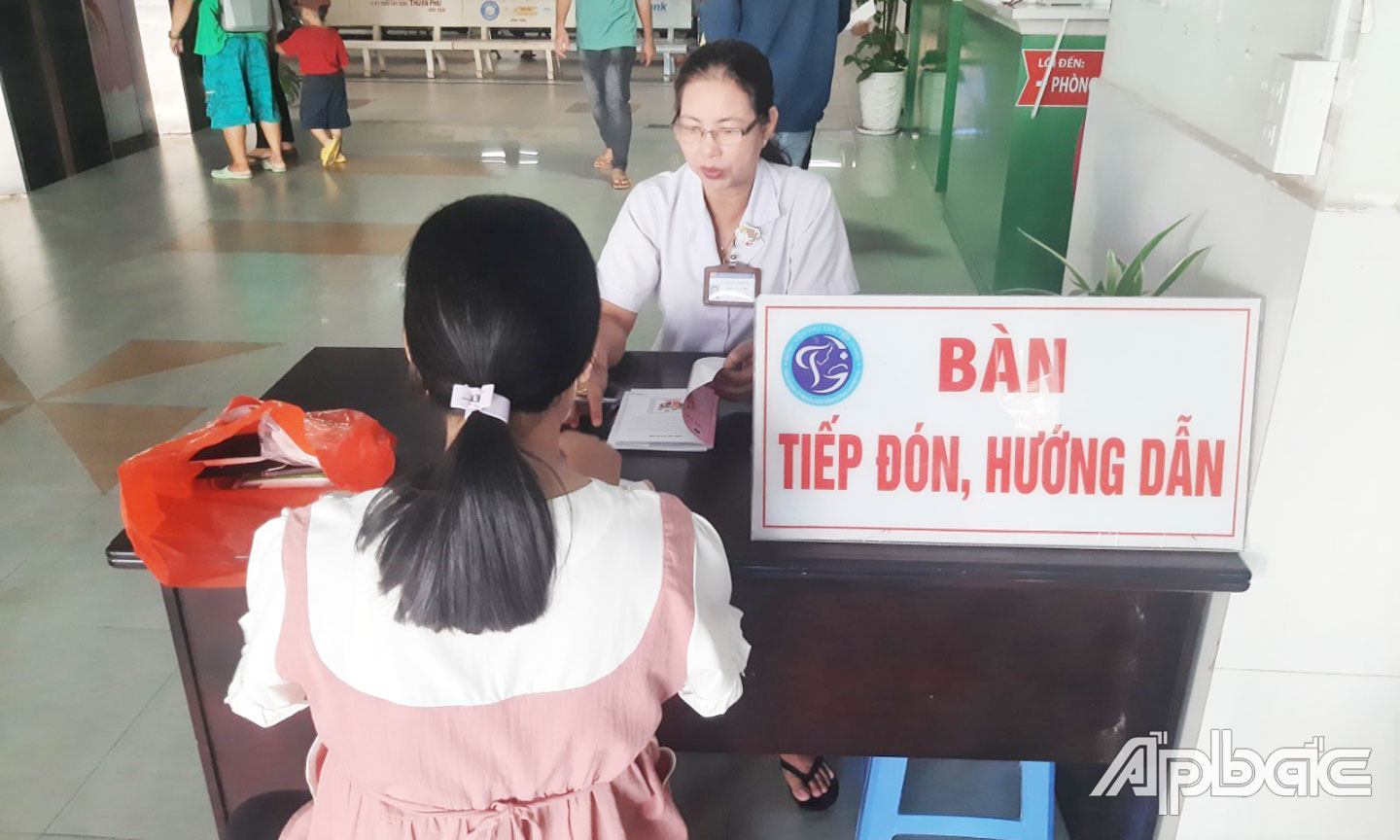 Nhân viên Tổ Công tác xã hội tư vấn và hướng dẫn người bệnh quét mã QR CCCD gắn chíp để ghi nhận thông tin khi khám bệnh