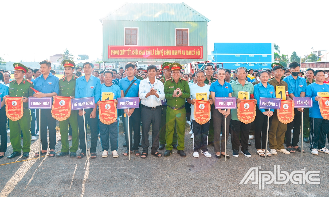  Đại tá Bùi Hữu Thiện, Trưởng Phòng Cảnh sát phòng cháy, chữa cháy và cứu nạn, cứu hộ - Công an tỉnh Tiền Giang và Phó Chủ tịch UBND TX. Cai Lậy Đoàn Bảo Ngoan trao cờ lưu niệm cho các đội thi trước khi bước vào phần thi lý thuyết.