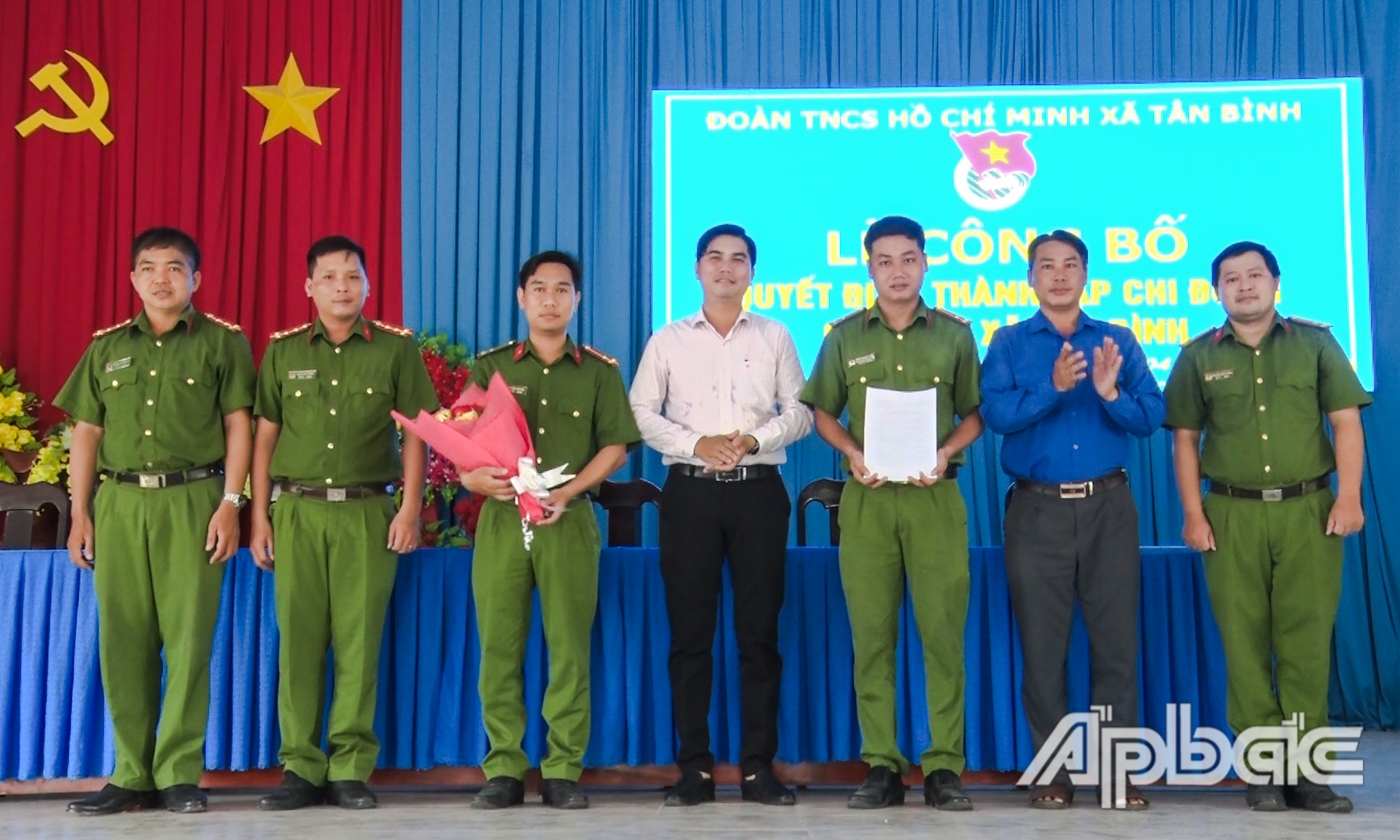 Anh Phạm Thanh Trà và anh Huỳnh Văn Hưởng trao Quyết định và tặng hoa chúc mừng Chi đoàn Công an xã Tân Bình.