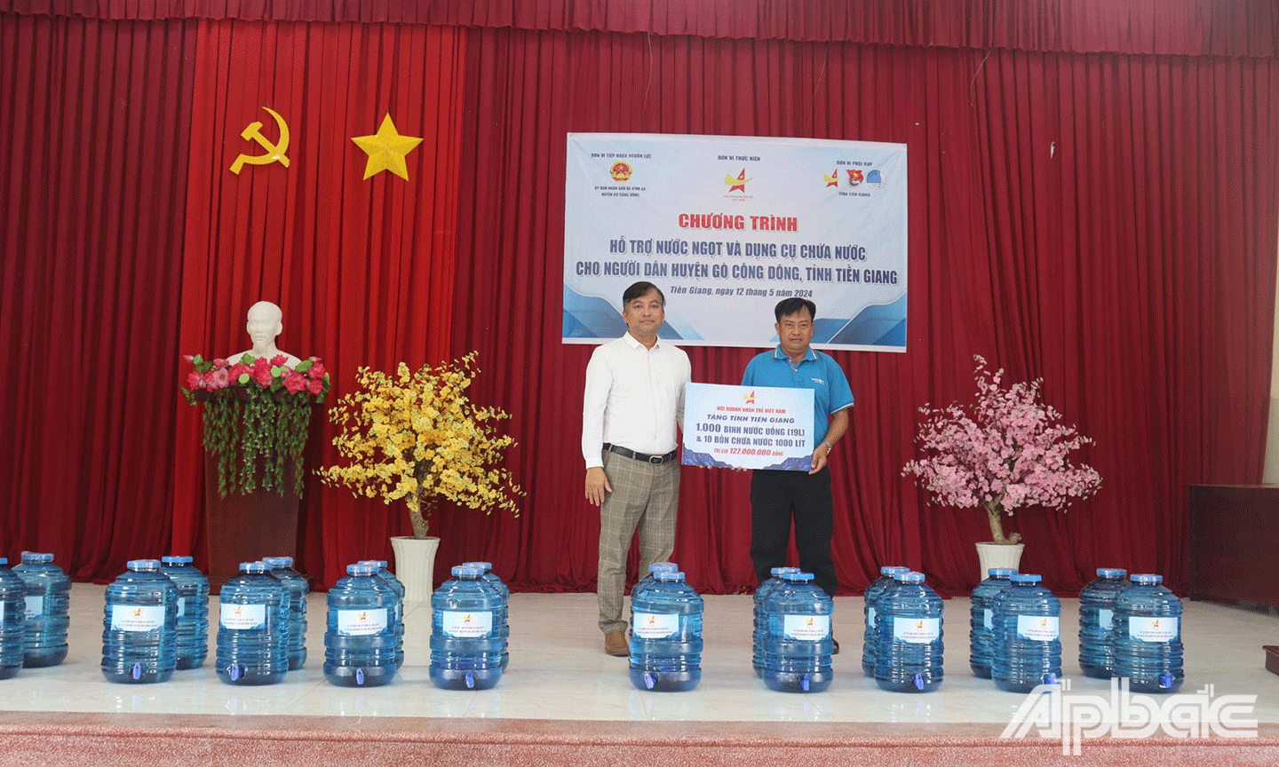 Đại diện Đoàn trao bảng tượng trưng bình nước uống và bồn nước cho bà con