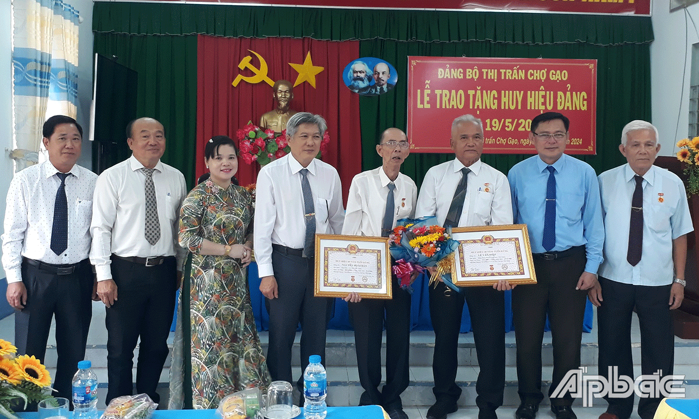 Đồng chí Đỗ Tấn Hùng trao huy hiệu Đảng cho 2 đảng viên tại Thị trấn Chợ Gạo.