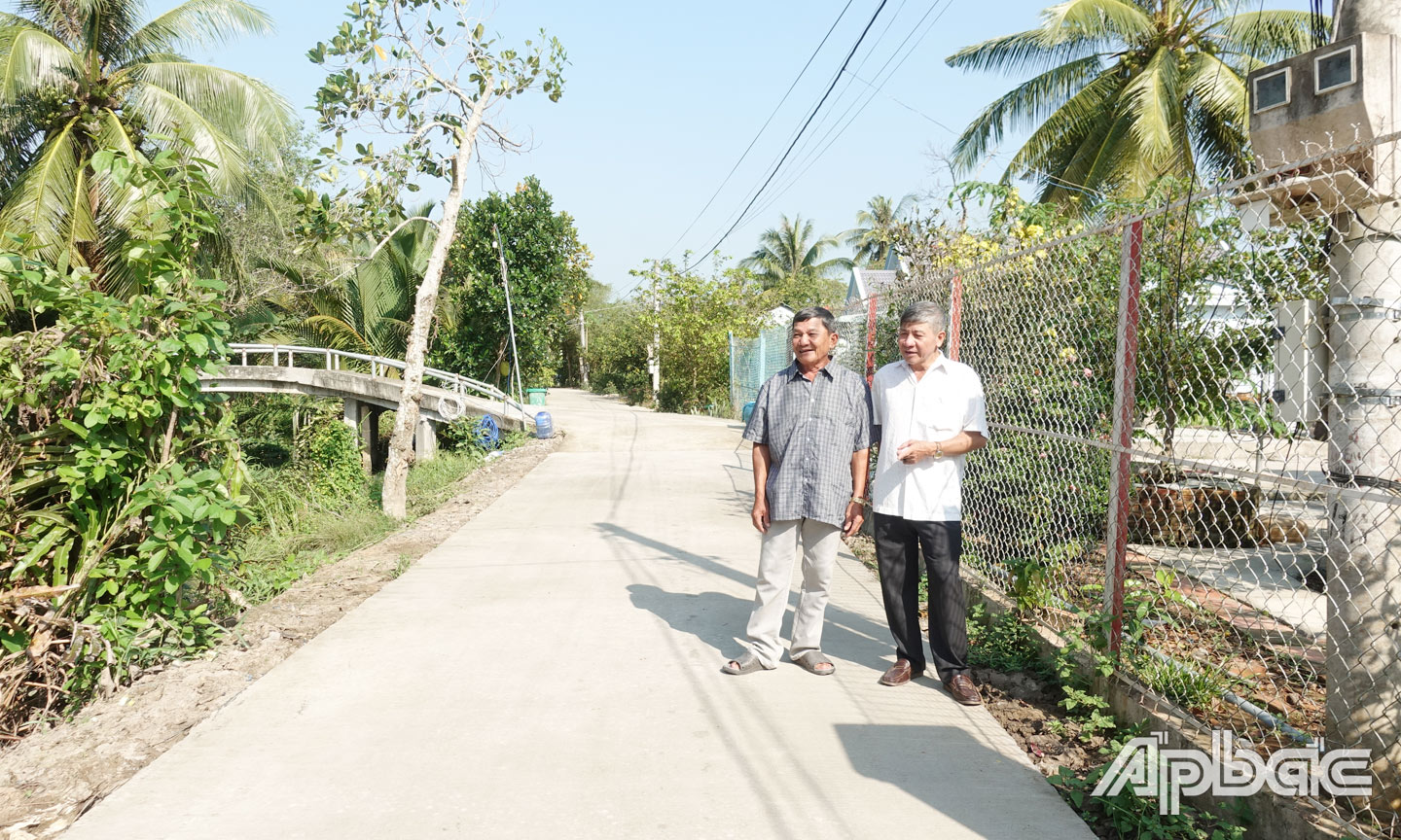 Ông Đặng Văn Tưởng (trái) bên tuyến đường Bắc Rạch Ông Cối do ông hiến đất mở rộng.