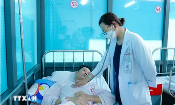 Bác sỹ Bệnh viện Đột quỵ-Tim mạch Cần Thơ thăm khám cho bệnh nhân N.V.R, bị ngưng tim ngoại viện, sau can thiệp. (Ảnh: TTXVN phát)