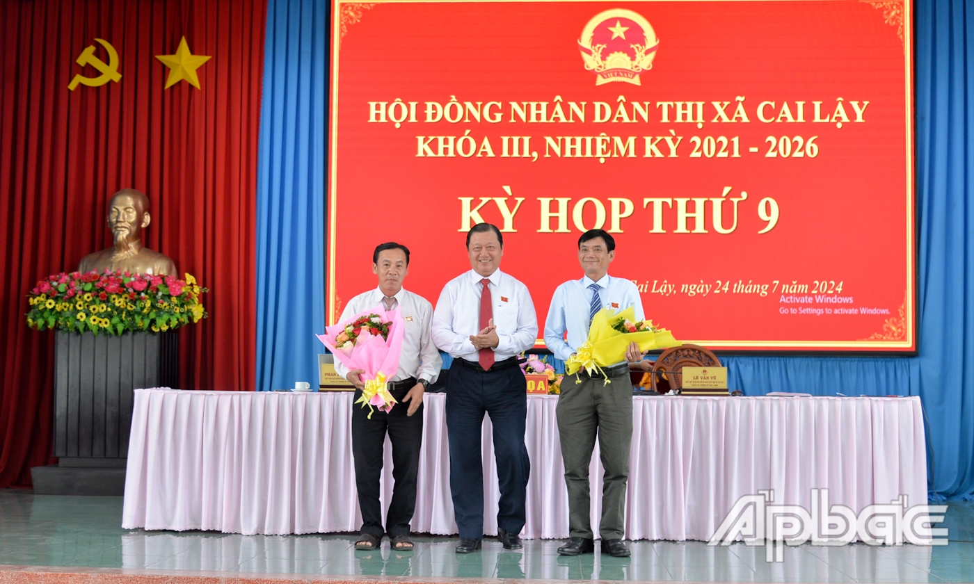 Đồng chí Phan Phùng Phú tặng hoa miễn nhiệm các đồng chí Ủy viên UBND thị xã khóa III, nhiệm kỳ 2021 - 2026.