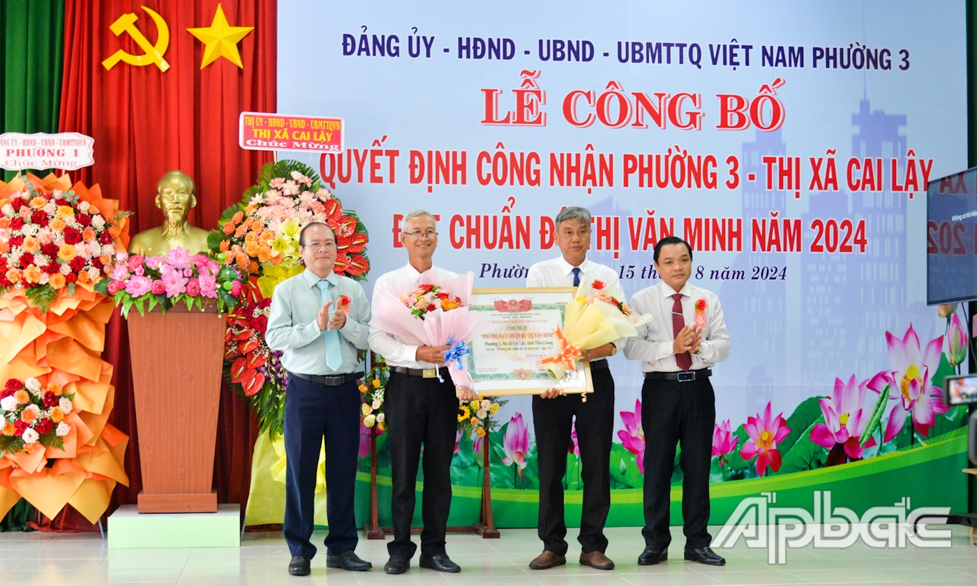 Đồng chí Phạm Văn Vạn và đồng chí Trần Văn Thức trao Quyết định công nhận “Phường đạt chuẩn đô thị văn minh” và tặng hoa chúc mừng phường 3.
