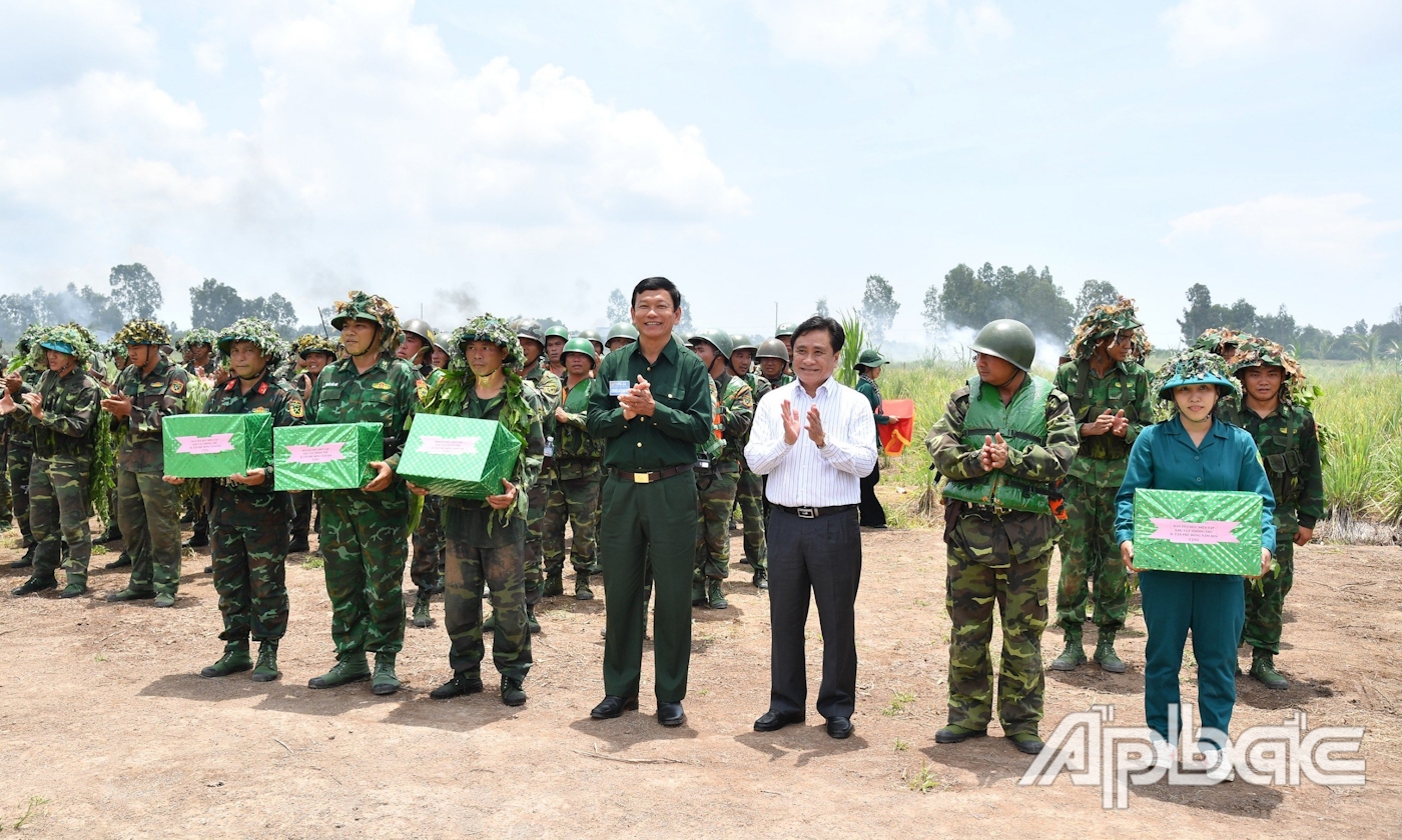 Đồng chí Trần Văn Dũng, Ủy viên Ban Thường vụ Tỉnh ủy, Phó Chủ tịch Thường trực UBND tỉnh và đồng chí Bùi Thái Sơn, Bí thư Huyện ủy, Chủ tịch UBND huyện Tân Phú Đông tặng hoa và quà động viên lực lượng Quân sự hoàn thành nhiệm vụ thực binh.
