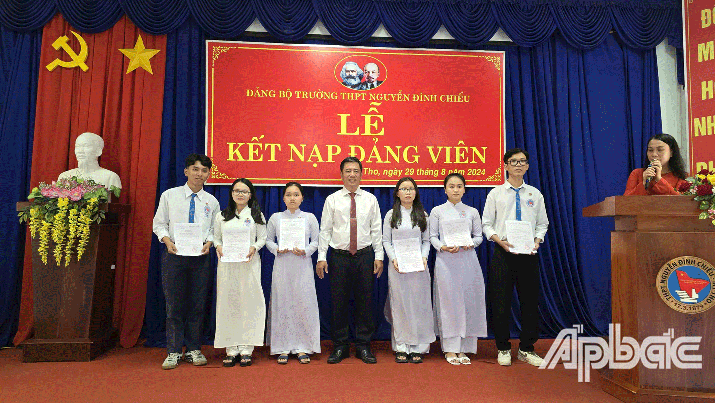 Bí thư Đảng ủy, Hiệu trưởng Trường THPT Nguyễn Đình Chiểu Võ Hoài Nhân Trung trao Quyết định Kết nạp đảng cho đảng viên mới. 