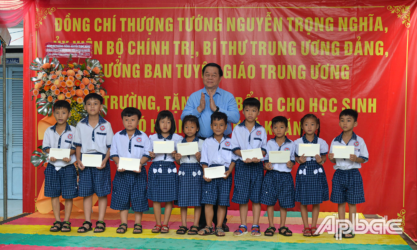 Đồng chí Nguyễn Trọng Nghĩa trao học bổng cho học sinh có hoàn cảnh khó khăn.