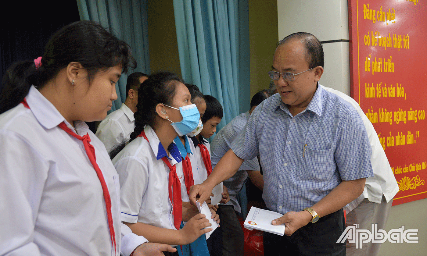 Đồng chí Nguyễn Chí Trung trao quà cho các em.