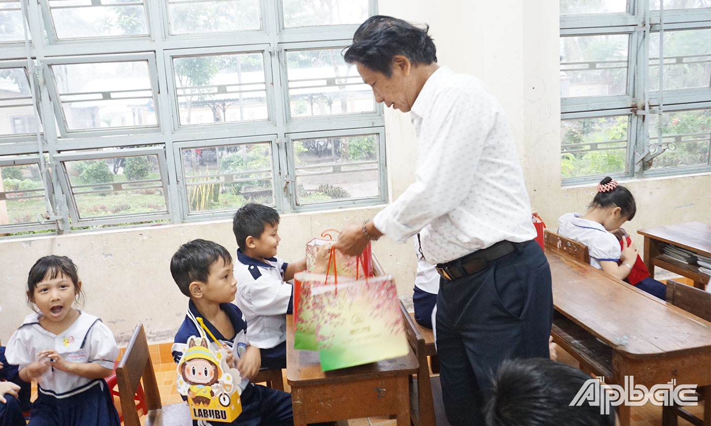 Đồng chí Phạm Văn Sơn, Phó Tổng Biên tâp Báo Ấp Bắc, Chủ tịch Công đoàn Cơ sở Báo Ấp Bắc trao quà trung thu cho các em tại trường Tiểu học xã Xuân Đông, huyện Chợ Gạo