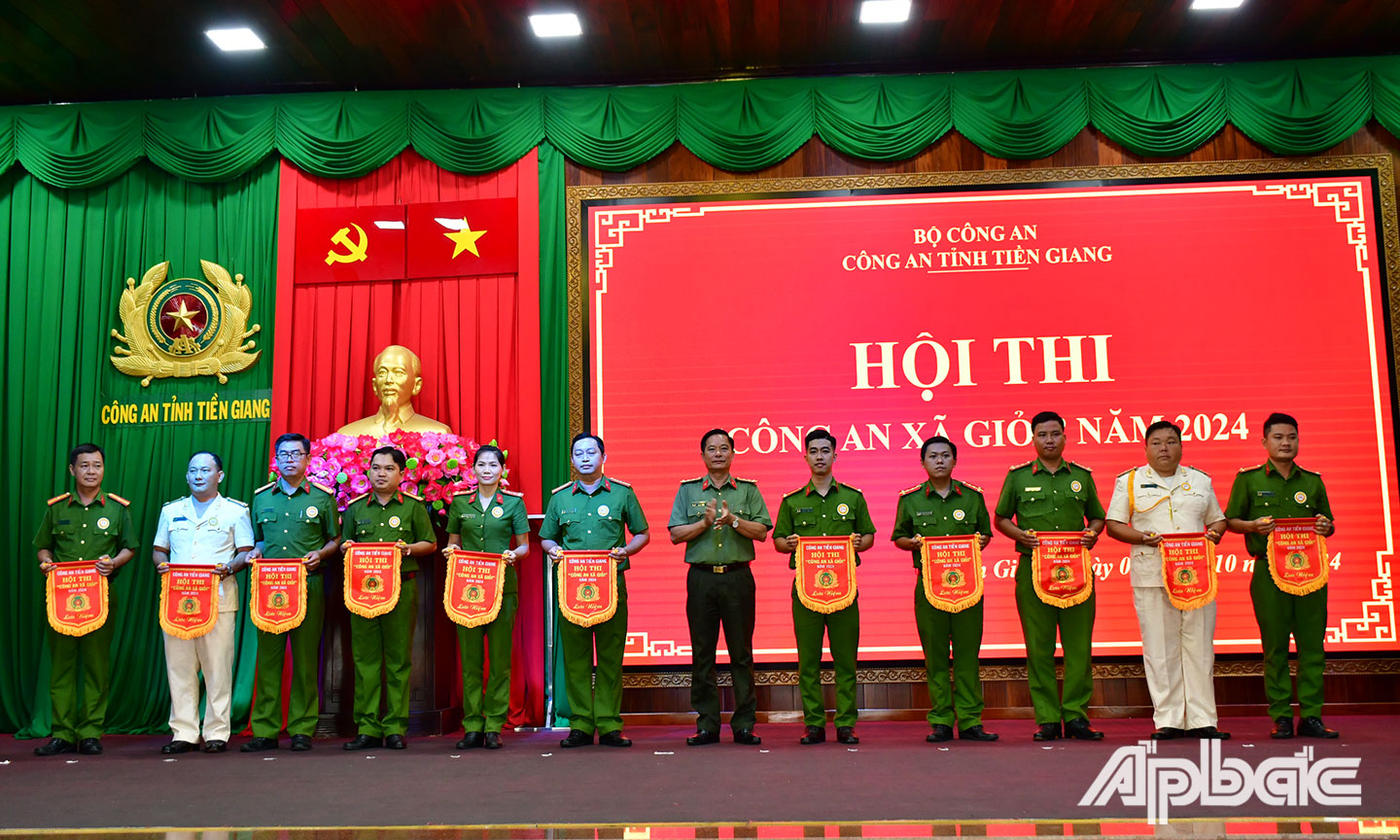 Đại tá Nguyễn Hồng Khắc, Phó Giám đốc Công an tỉnh trao Cờ lưu niệm tặng 11 Đội Công an xã thuộc Công an các huyện, thành phố, thị xã. Ảnh Đặng Thanh