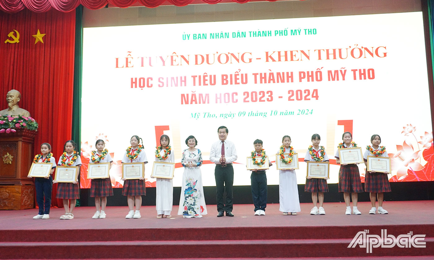 Đại biểu trao Giấy khen và vòng nguyệt quế cho các em học sinh xuất sắc của các trường phổ thông