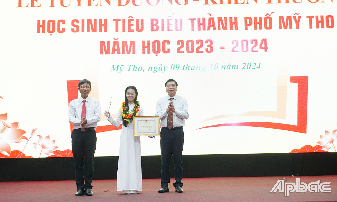 Đại biểu trao Giấy khen và vòng nguyệt quế cho 2 em học sinh tiêu biểu Trần Khánh Giang và Nguyễn Ngọc Gia Hân
