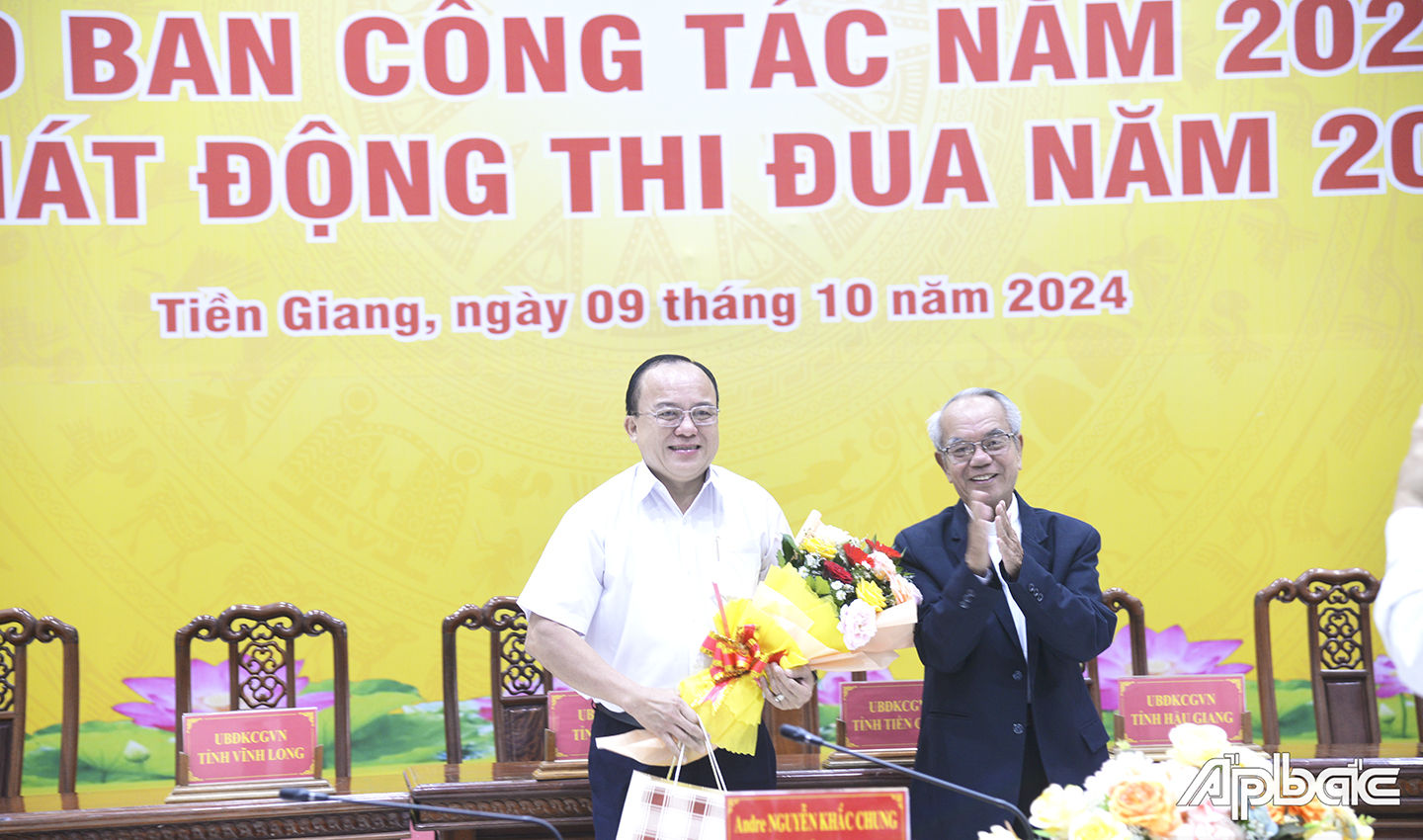 Linh mục Phan Đình Sơn, Phó Chủ tịch Ủy ban ĐKCG Việt Nam trao quà lưu niệm đến đồng chí Nguyễn Chí Trung, Chủ tịch Ủy ban MTTQ VN tỉnh Tiền Giang 
