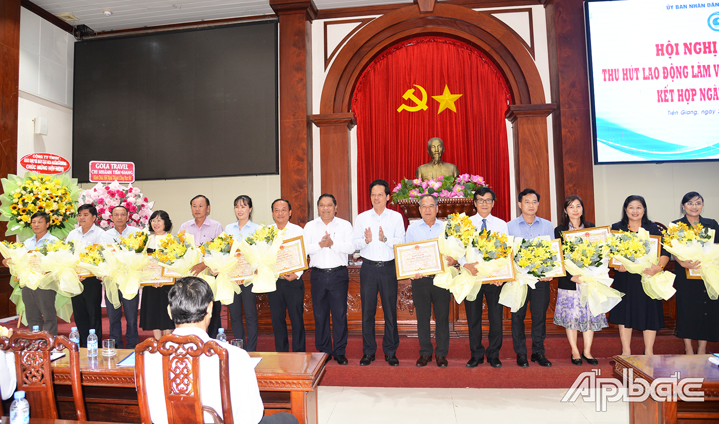 Đồng chí Nguyễn Thành Diệu, Phó Chủ tịch UBND tỉnh trao Bằng khen và đồng chí Lý Văn Cẩm, Giám đốc Sở LĐ-TB&XH trao hoa chúc mừng  cho các đơn vị