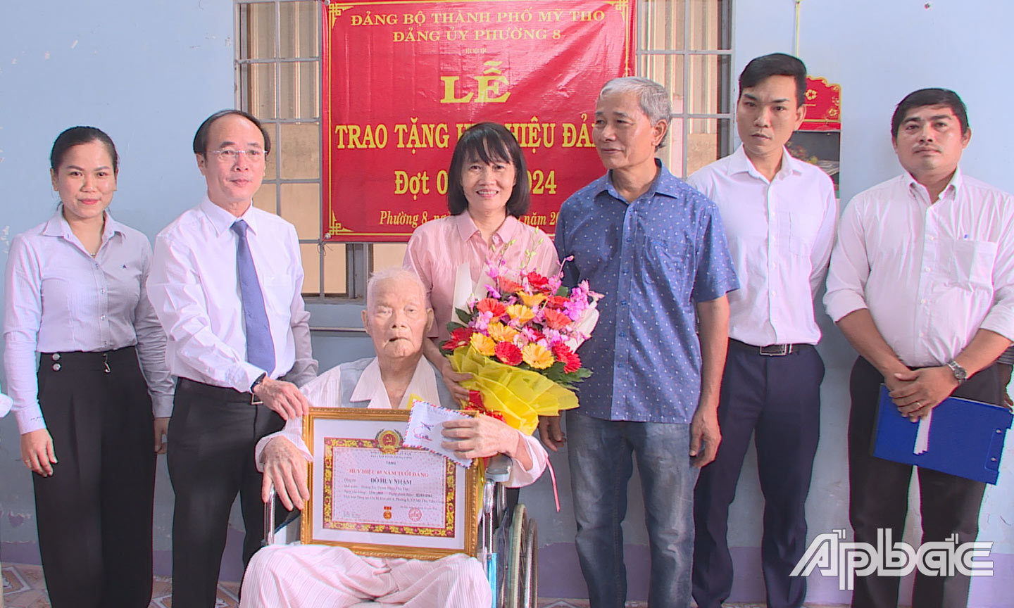 Bí thư Thành ủy Mỹ Tho trao tặng Huy hiệu 65 năm tuổi Đảng cho đảng viên Đỗ Huy Nhậm.