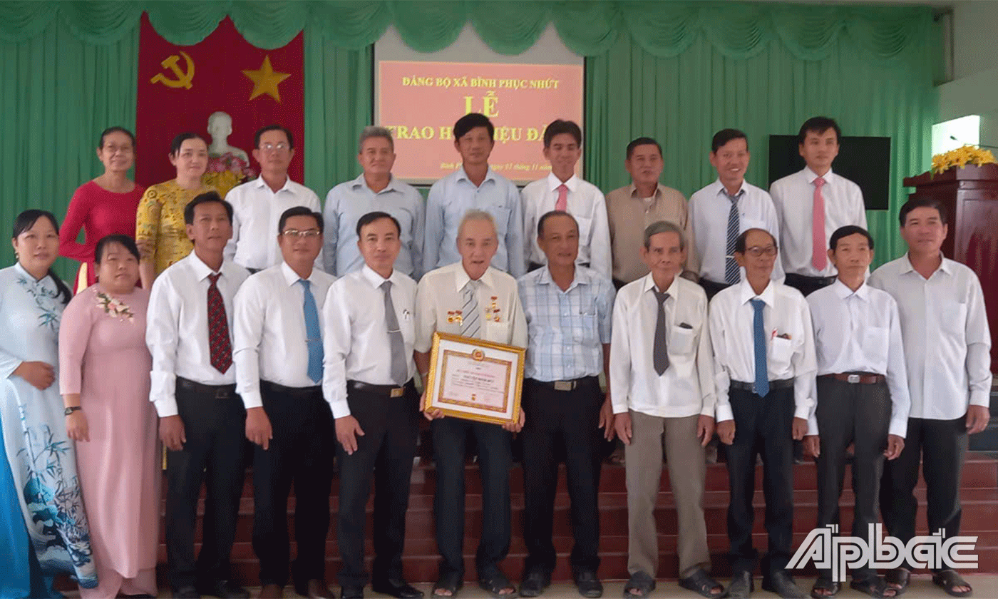 Đồng chí Phạm Hùng Vinh, Phó Bí thư huyện uỷ, Chủ tịch UBND huyện trao Huy hiệu 50 năm tuổi Đảng cho đảng viên Nguyễn Minh Đức, 