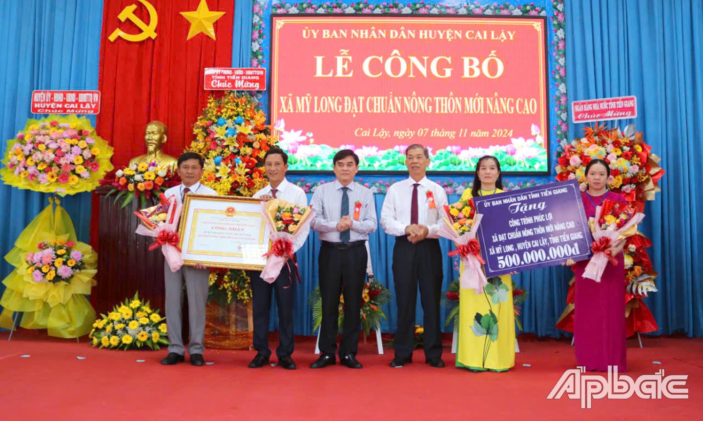 rao Bằng công nhận xã đạt chuẩn NTM nâng cao và Bảng tượng trưng tặng công trình phúc lợi cho xã Tân Trung.