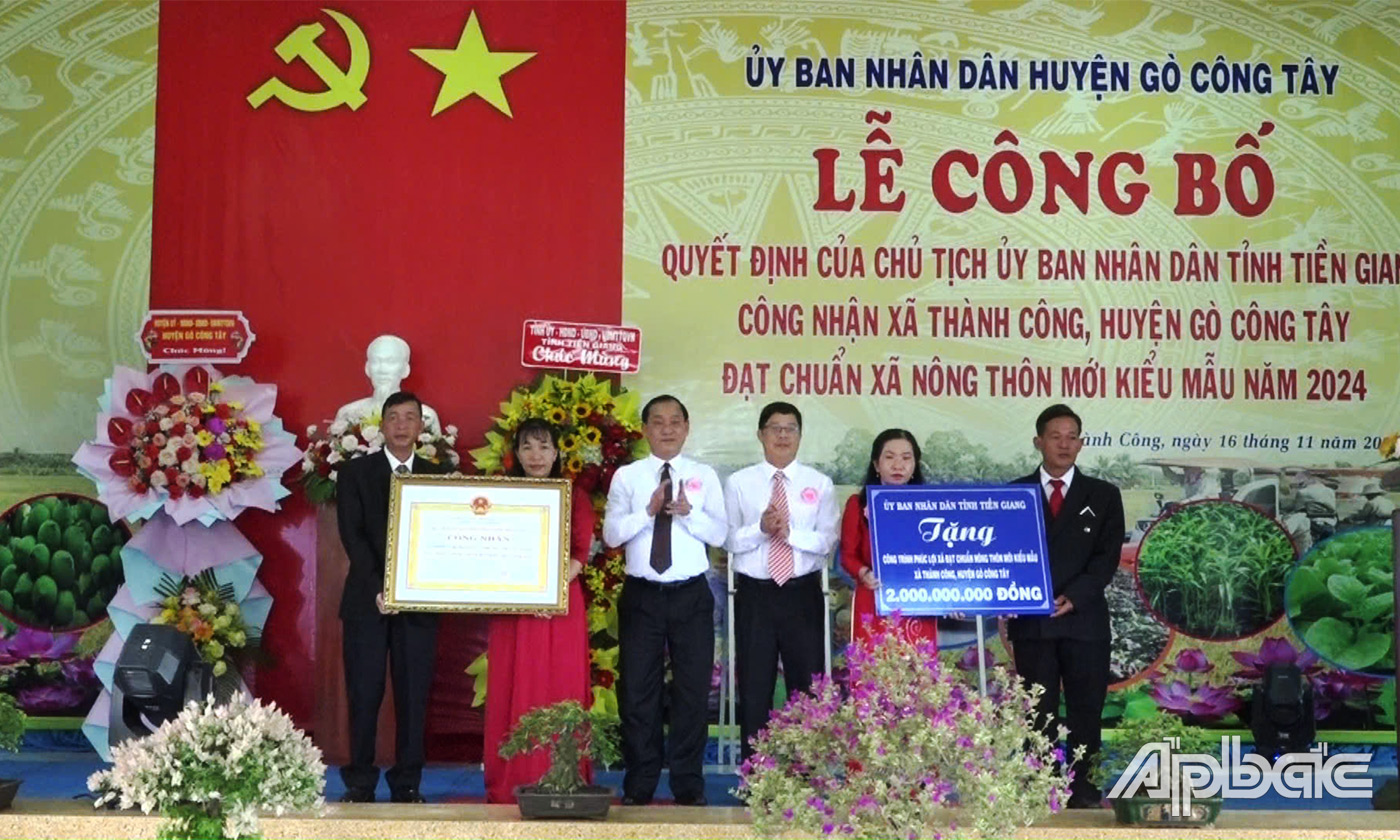 Đồng chí Phạm Văn Trọng, Phó Chủ tịch UBND tỉnh Tiền Giang và đồng chí Trần Hoàng Nhật Nam, Phó Giám đốc Sở Nông nghiệp và Phát triển nông thôn tỉnh Tiền Giang trao Bằng công nhận đạt chuẩn NTM kiểu mẫu và Bảng tượng trưng tặng công trình phúc lợi 2 tỷ đồng cho xã NTM kiểu mẫu