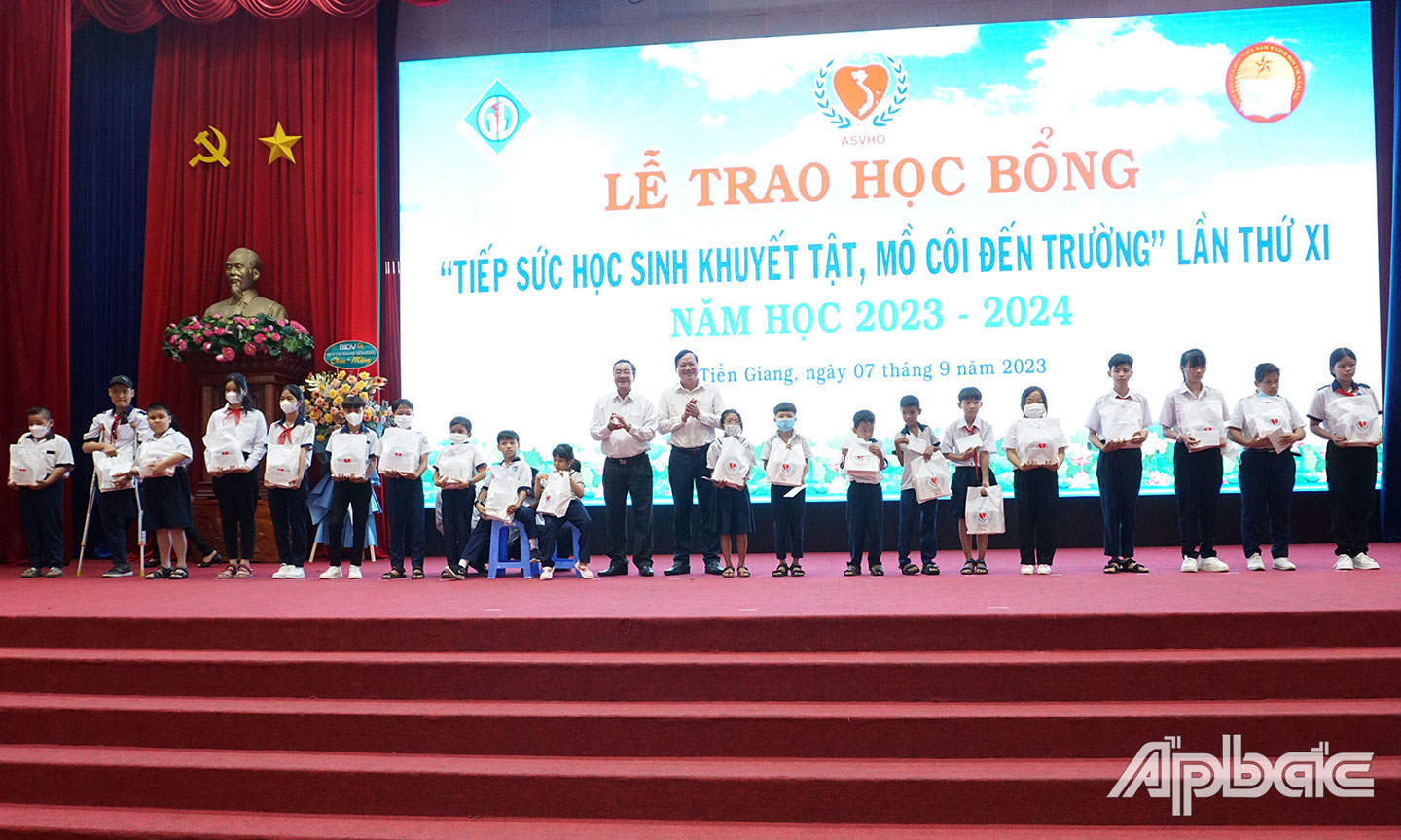 Đại biểu  trao học bổng cho học sinh khuyết tật và  trẻ mồ côi trên địa bàn tỉnh. 