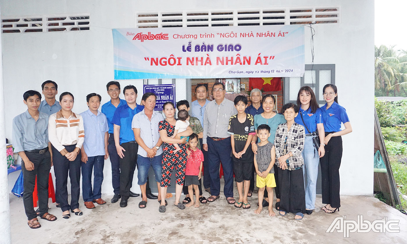 Đại biểu chụp ảnh lưu niệm cùng gia đình anh Nguyễn Hữu Tài bên căn nhà mới. 