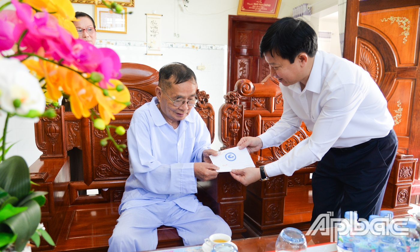 Đồng chí Lê Quang trí, Giám đốc Sở Giáo dục và Đào tạo thay mặt đoàn công tác thăm, tặng quà Đại tá Ngô Văn Chính, nguyên Phó Tham mưu trưởng Bộ Chị huy Quân sự tỉnh Tiền Giang.