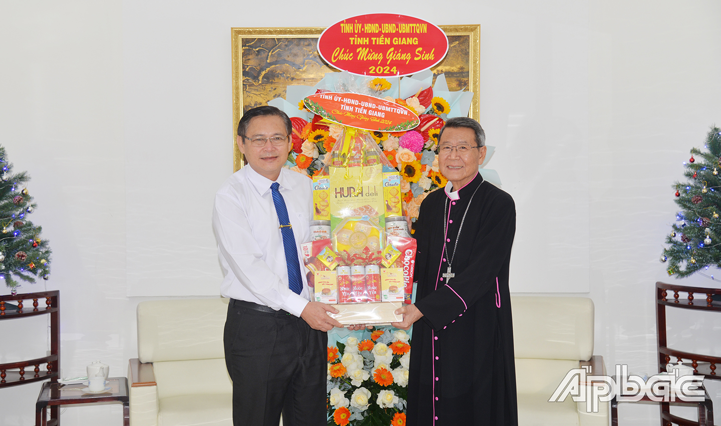 Trưởng Ban Dân vận Tỉnh ủy Đỗ Tấn Hùng trao hoa và quà chúc mừng Giáng sinh đến Giám mục Giáo phận Mỹ Tho Nguyễn Văn Khảm.