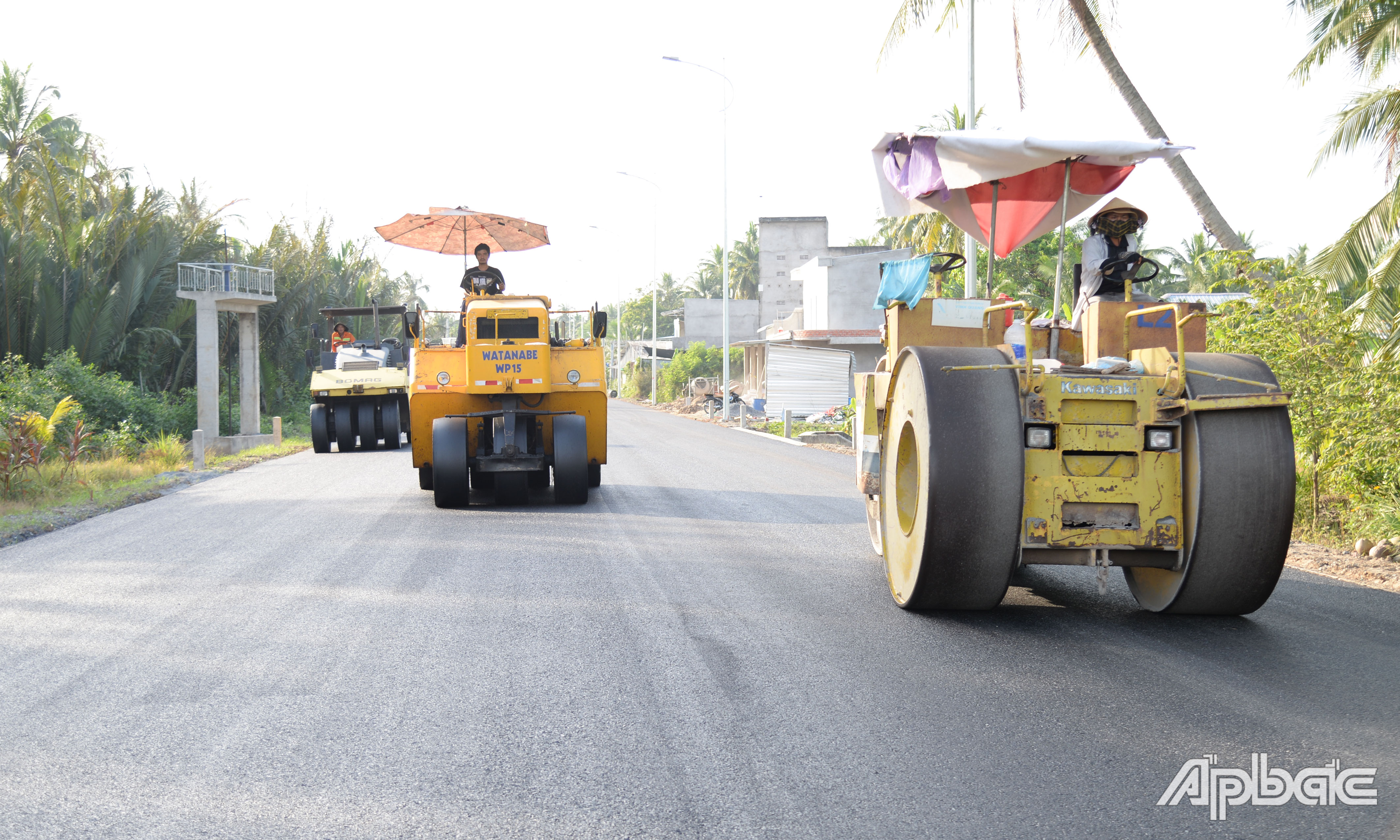 Nhà thầu huy động nhiều nhân lực thiết bị để thảm nhựa mặt đường.