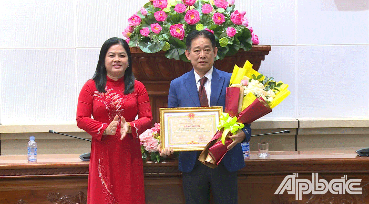 Thừa ủy quyền của UBND tỉnh Tiền Giang, Phó Gi ám đốc Sở GD-ĐT Huỳnh Thị Phượng trao Bằng khen cho tổ chức FHF. 