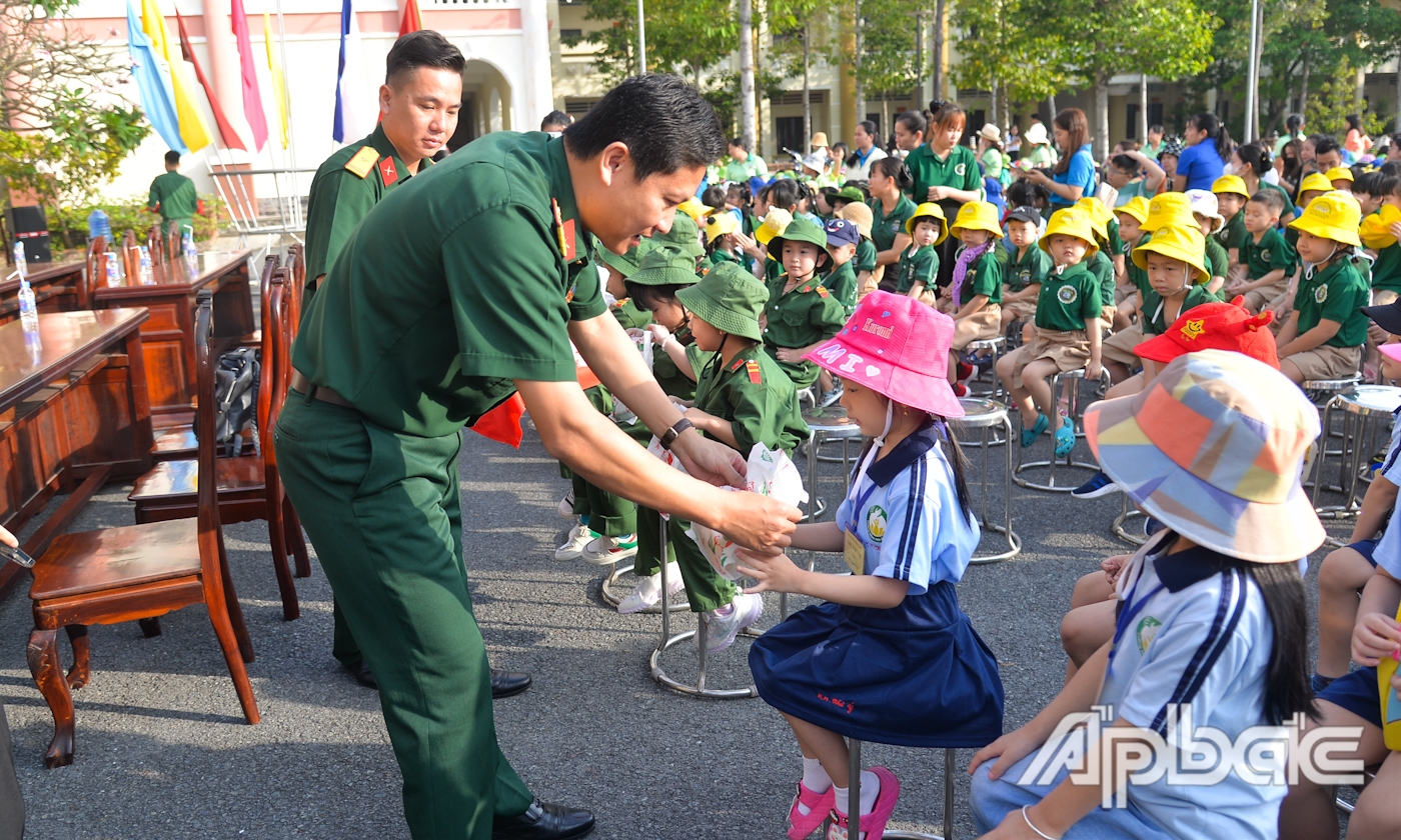  Các cô, chú bộ đội tặng quà cho các cháu thiếu nhi.