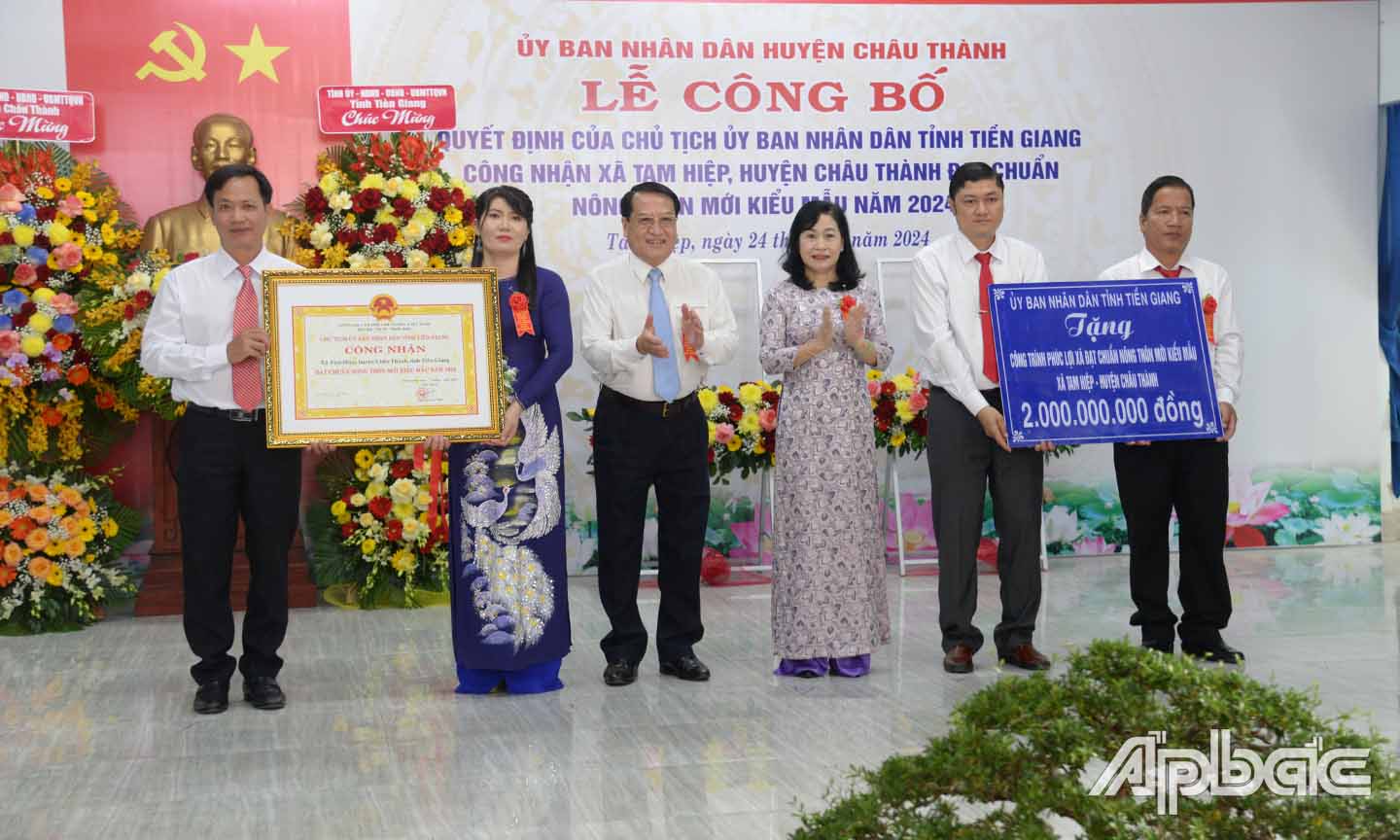 Đồng chí Châu Thị Mỹ Phương và đồng chí Phạm Văn Trọng trao bằng công nhận xã đạt chuẩn NTM kiểu mẫu và bảng tượng trưng tặng công trình phúc lợi trị giá 500 triệu đồng cho xã Tam Hiệp.