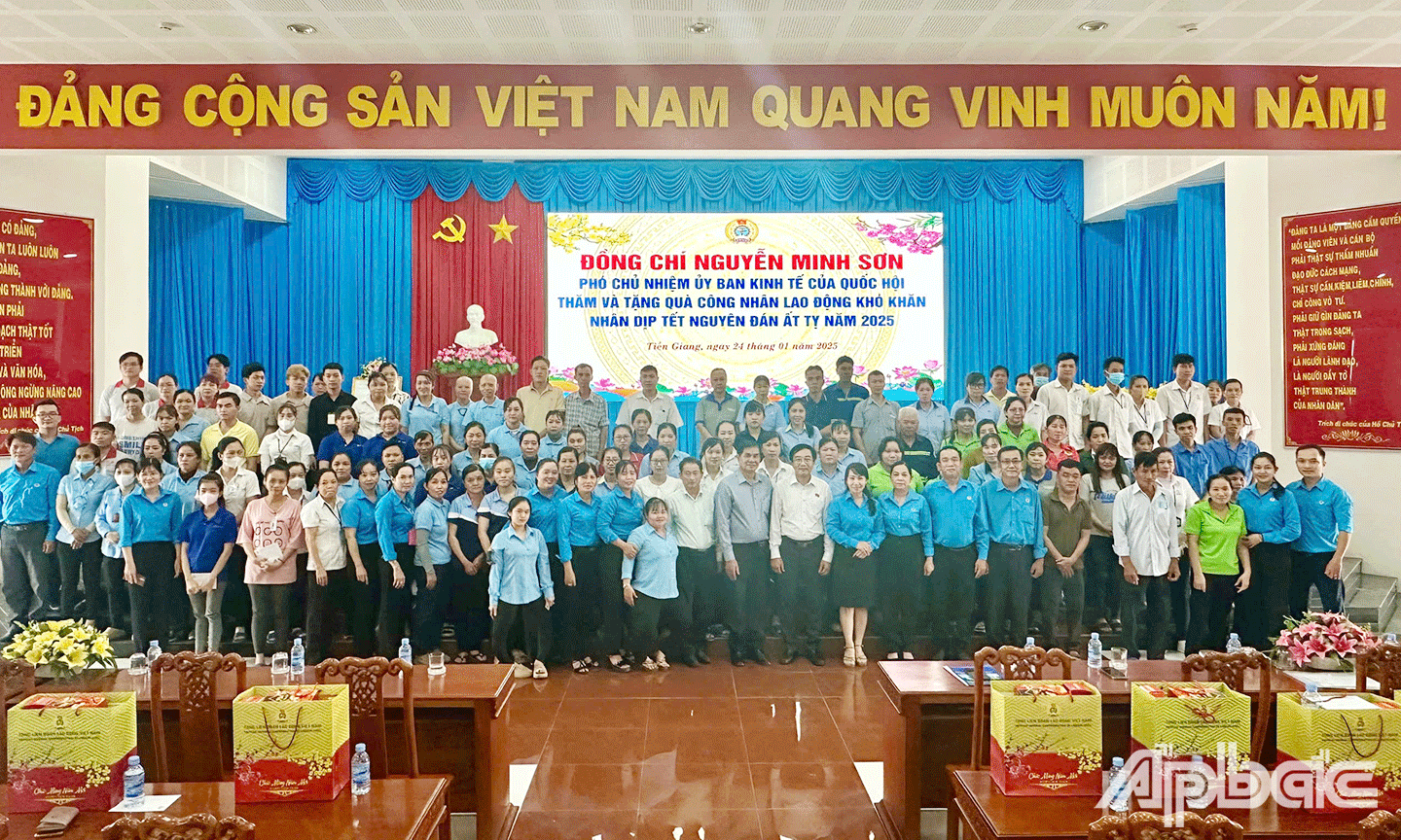 Đại biểu cùng công nhân lao động được trao tặng quà tại chương trình chụp ảnh lưu niệm