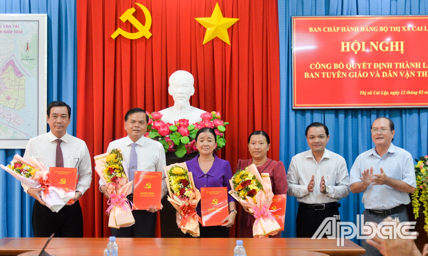 Đồng chí Phạm Văn Vạn và đồng chí Trần Văn Thức trao Quyết định bổ nhiệm cán bộ lãnh đạo, quản lý Ban Tuyên giáo và Dân vận Thị ủy và tặng hoa chúc mừng.