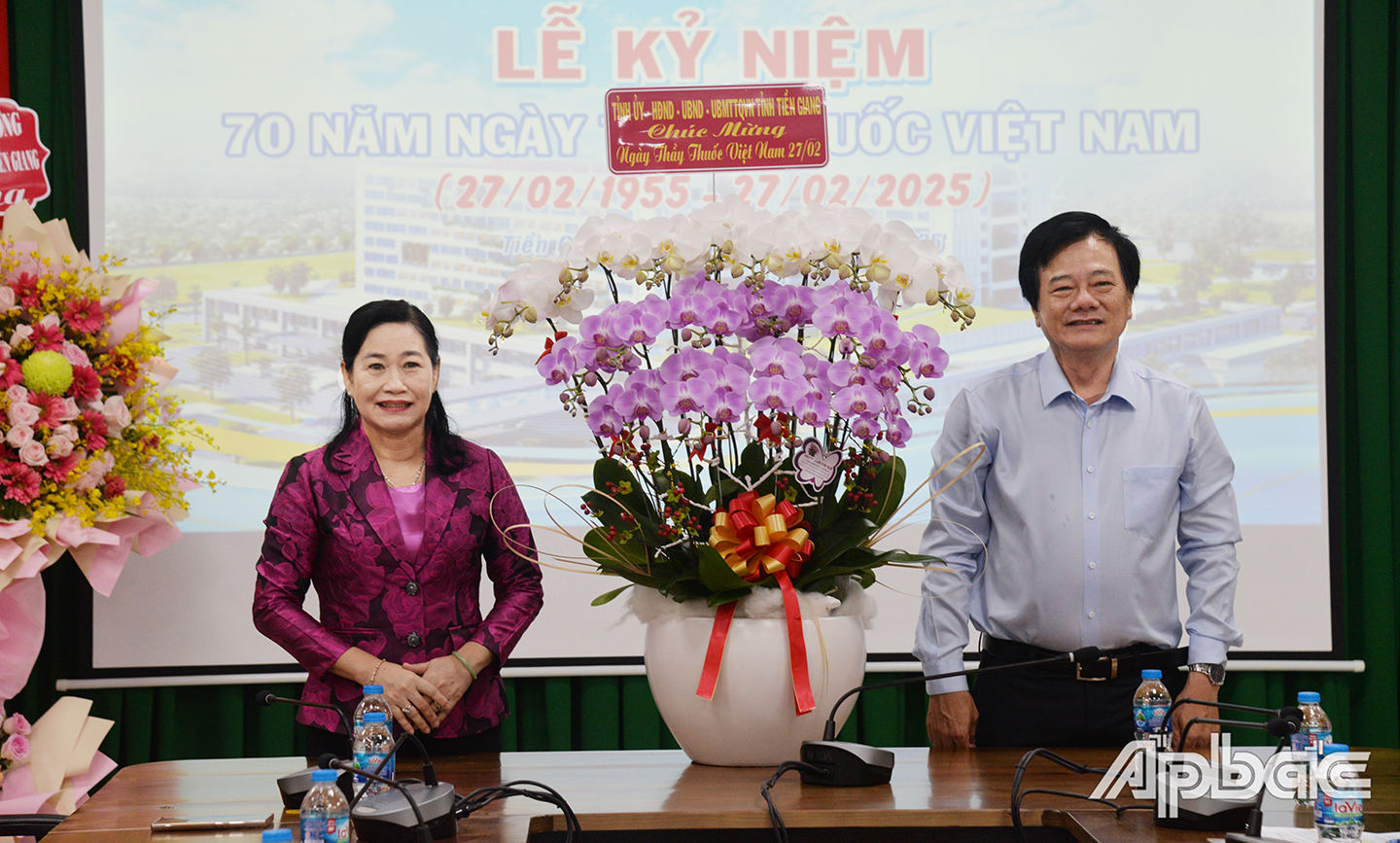 Đồng chí Châu Thị Mỹ Phương trao hoa chúc mừng của Tỉnh ủy, HĐND, UBND, Ủy ban MTTQ tỉnh đến Giáo sư Tạ Văn Trầm, Giám đốc Bệnh viện đa khoa Tiền Giang