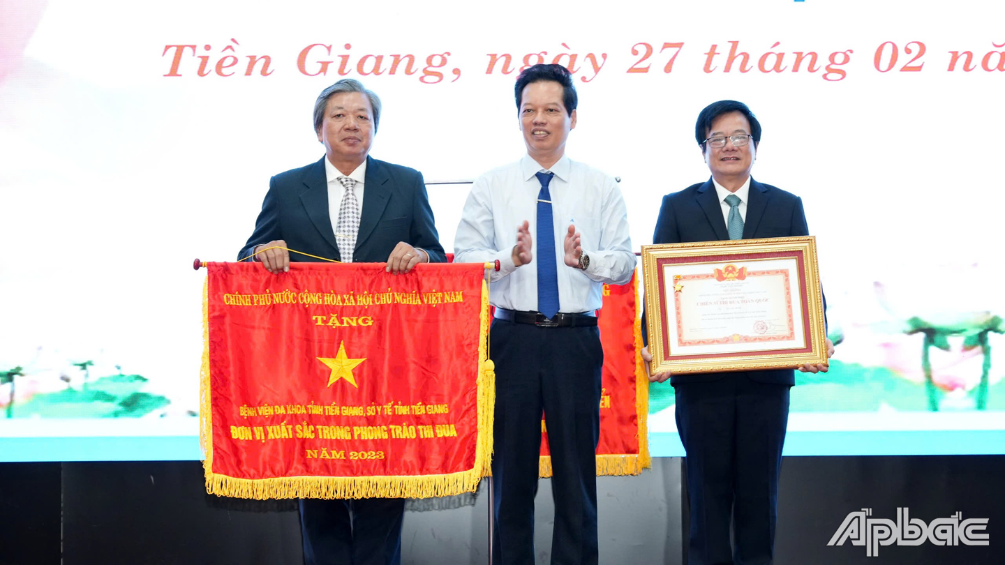 Đồng chí Nguyễn Thành Diệu, Tỉnh ủy viên, Phó Chủ tịch UBND tỉnh trao Cờ thi đua xuất sắc của chính phủ cho lãnh đạo Bệnh viện đa khoa Tiền Giang và Bằng công nhận Chiến sĩ thi đua toàn quốc cho Thầy thuốc nhân dân Tạ Văn Trầm