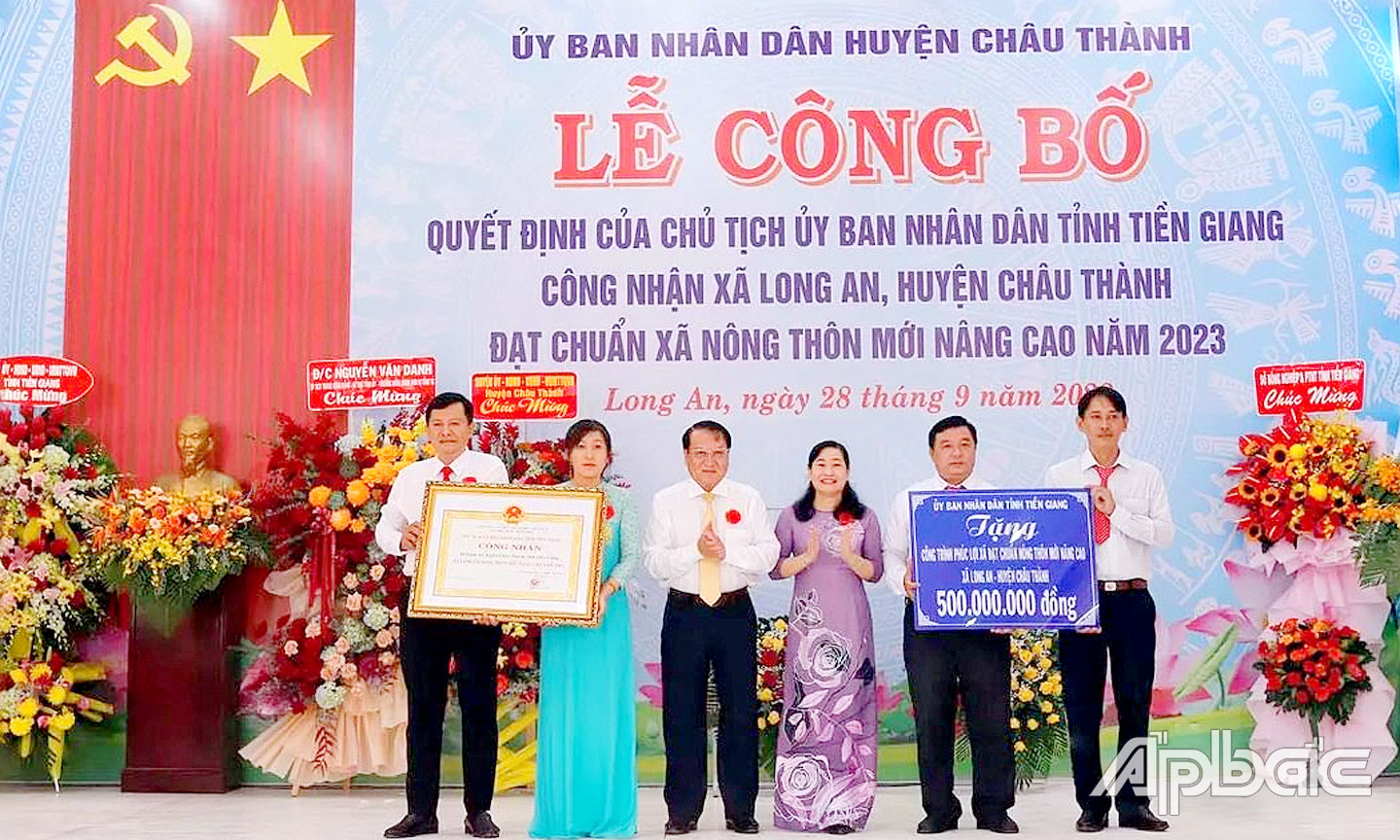 Lãnh đạo tỉnh trao Bằng công nhận xã NTM nâng cao và Bảng tượng trưng tặng công trình phúc lợi cho xã Long An.                             Ảnh: CAO THẮNG
