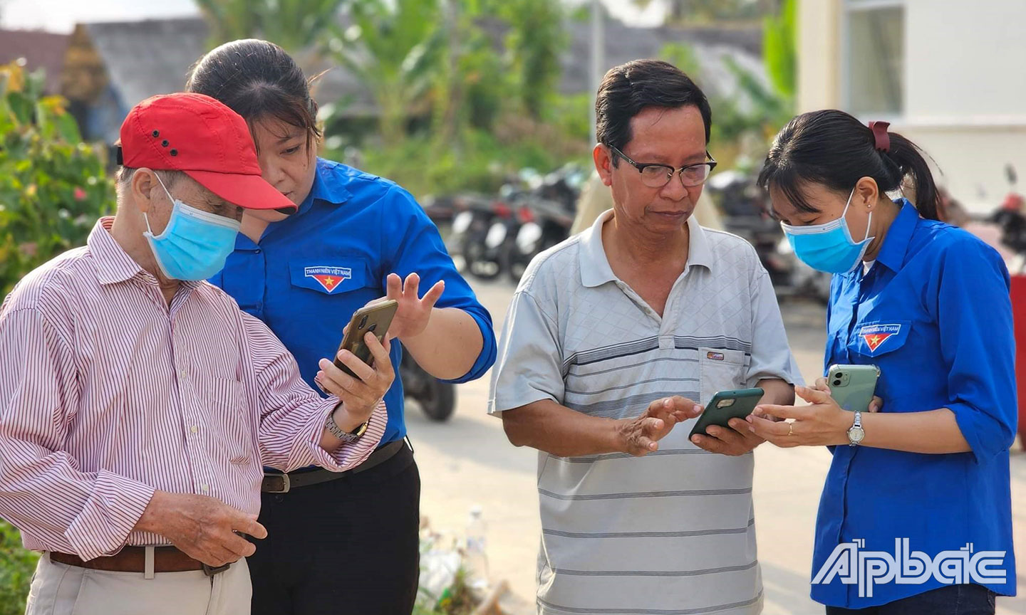 Đoàn viên thanh niên hỗ trợ cài đặt ứng dụng VNeID cho người dân.