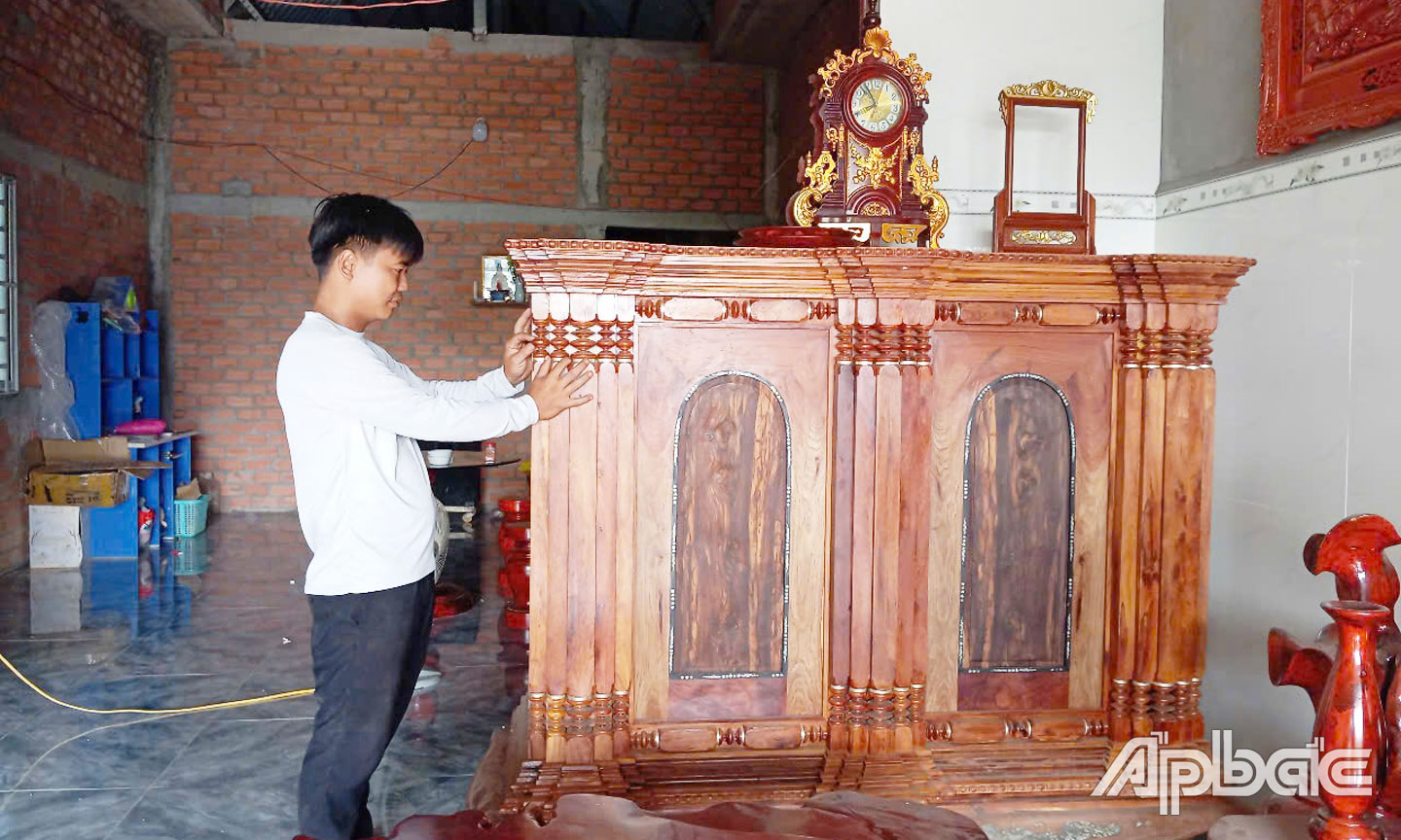 Anh Trí đang lắp các bông dâu tủ thờ.